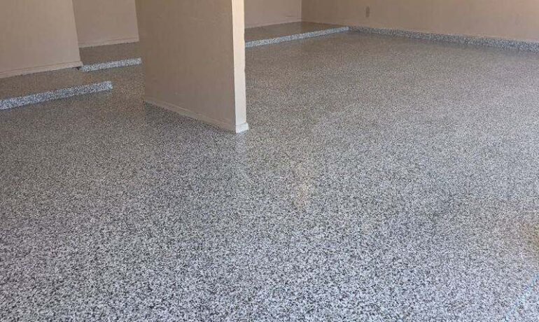 Piso epóxico sobre cemento viejo en una cochera de El Paso, acabado en hojuela domino por Epoxee