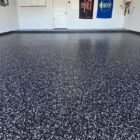 How we epoxy a garage floor in winter in El Paso: raven flake system going down on a slab that cleared 50°F by noon