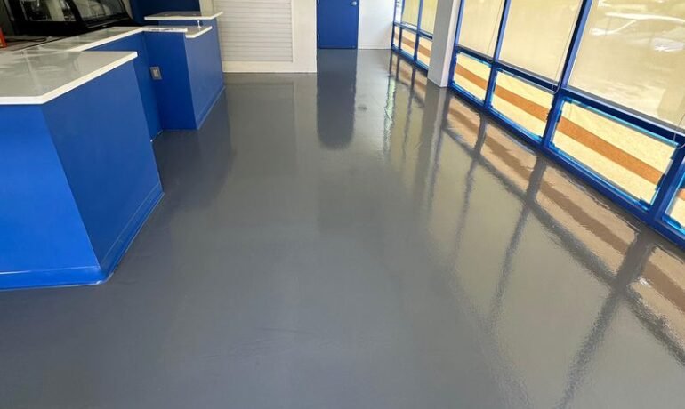 Piso epóxico gris brillante en un local comercial, fácil de limpiar piso epóxico con trapeador y detergente suave